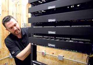 Siebern Visser, a member of the information technology department at Park Place of Elmhurst in suburban Chicago, tends to some of the behind-the-scenes equipment his department oversees. Technical dem Siebern Visser, a member of the information technology department at Park Place of Elmhurst in suburban Chicago, tends to some of the behind-the-scenes equipment his department oversees. Technical dem